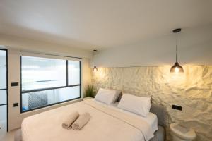 a bedroom with a bed with two towels on it at NOMA Suites in Kalamata