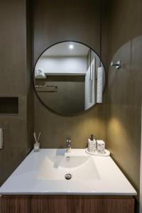 a bathroom with a white sink and a mirror at NOMA Suites in Kalamata +7 photos