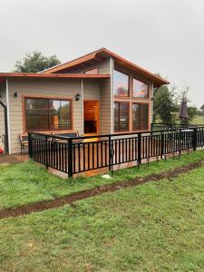 a small house with a fence in front of it at Casa Costanera in Panguipulli