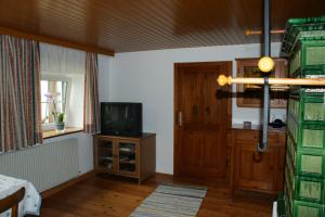 a bedroom with a tv and a wooden door at Schlagerberg in Scharnstein