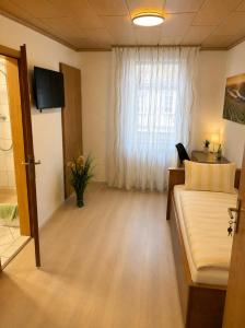 a living room with a couch and a window at Bed and Breakfast - Rheingauer Hof in Oestrich-Winkel