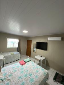 a hotel room with two beds and a flat screen tv at Pousada do Gil in Iguatu