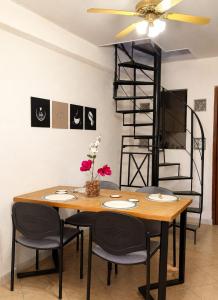 a dining room table with chairs and a ceiling fan at Caelum House Apartamento Con cochera in Rafaela