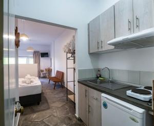 a kitchen with a sink and a room with a bed at Studio Lia in Skala Marion