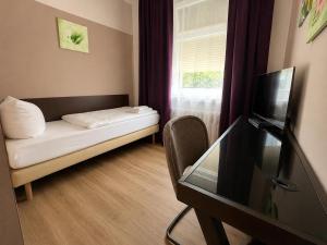 a small room with a couch and a television at Pension Reiter in Berlin