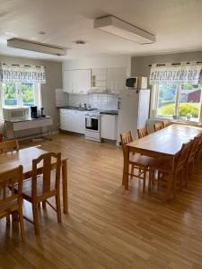 a kitchen and dining room with a table and chairs at Norrfällsvikens Vandrarhem in Mjällom