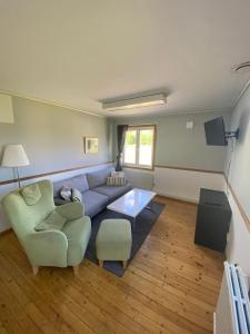 a living room with a couch and a chair at Norrfällsvikens Vandrarhem in Mjällom