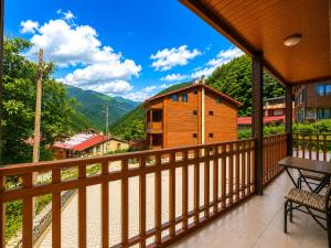 a balcony with a view of a town and mountains at Şimo Suite Otel in Uzungöl