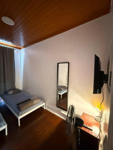 a bedroom with a mirror and a bed and a chair at Lisboa Parque Guest House in Lisbon