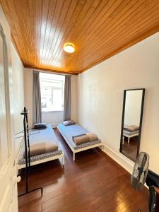 two beds in a room with a mirror at Lisboa Parque Guest House in Lisbon