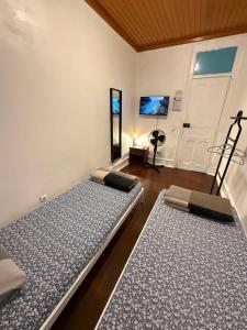 two beds sitting in a room with a door at Lisboa Parque Guest House in Lisbon