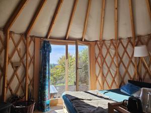 a room with a tent with a bed and a window at Ałabajka jurta i camping in Wleń