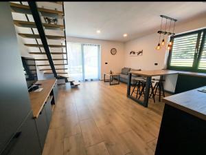 a kitchen and living room with a table and stairs at Riverside Apartma 1, Kranjska Gora in Kranjska Gora +30 photos
