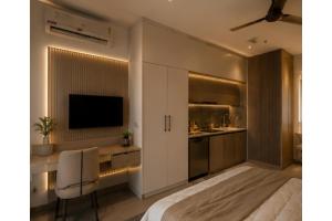 a bedroom with a bed and a desk with a television at Hotel Supreme Castle - Okhla Bird Sanctuary in Noida