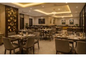 a restaurant with tables and chairs in a room at Hotel Supreme Castle - Okhla Bird Sanctuary in Noida