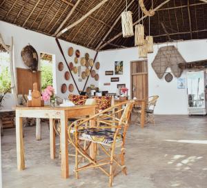 a dining room with a wooden table and chairs at Tunu Beach Zanzibar in Kizimkazi