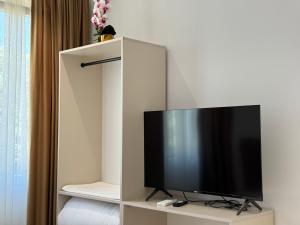 a flat screen tv sitting on a stand in a room at Hotel Djakbe in Tirana