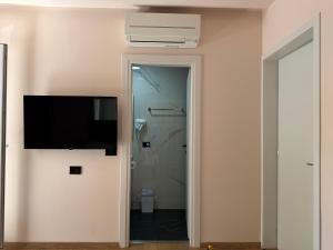a bathroom with a toilet and a television on a wall at Hotel Djakbe in Tirana