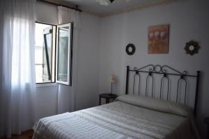 a bedroom with a bed and a window at Casa Nicolás in Portomarin