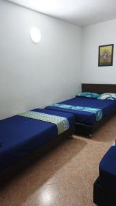 two beds sitting next to each other in a room at Hotel Oriente Real in Rionegro