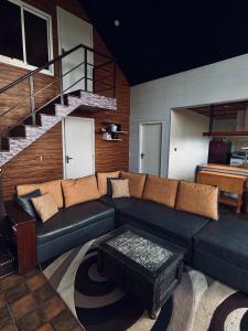 a living room with a couch and a staircase at The Margallia in Islamabad