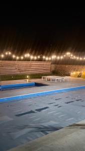 a swimming pool at night with benches and lights at Malishka Eco Villas in Malishka