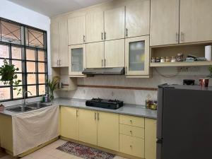 a kitchen with wooden cabinets and a sink and a refrigerator at Casa Sara in Nilai