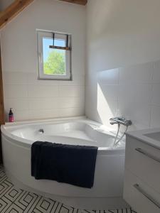 una vasca da bagno bianca in un bagno con una finestra di Chill and Grill - Modlin Airport Apartamenty na wynajem a Wola Smolana