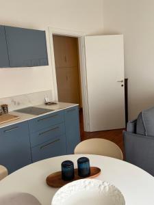 a room with a table and chairs and a kitchen at Verde Acqua two Apartments in Lecco