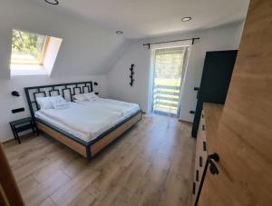 a bedroom with a bed and a large window at Riverside Apartma 1, Kranjska Gora in Kranjska Gora