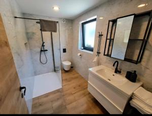 a white bathroom with a shower and a sink at Riverside Apartma 1, Kranjska Gora in Kranjska Gora