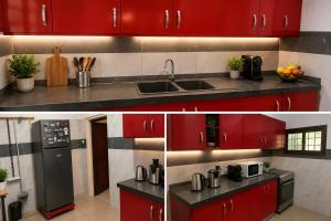 a kitchen with red cabinets and a sink at JONARIC Residence - Luxury Villa in Lomé in Azyagbang