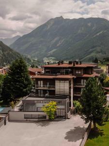 a large building with mountains in the background at Arx Boutiquehotel in Schladming