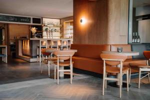 a restaurant with tables and chairs and a bar at Arx Boutiquehotel in Schladming