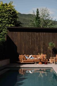 a person laying on a couch next to a pool at Arx Boutiquehotel in Schladming