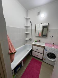 a bathroom with a tub and a washing machine at Квартира in Balqash