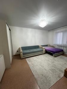 an empty room with two beds and a rug at Квартира in Balqash