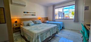 a bedroom with two beds and a window at Águas de Canto Grande in Bombinhas