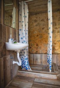 a bathroom with a sink and a shower curtain at My Olive Garden Camp in Bar