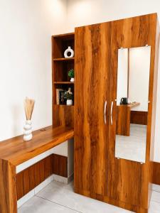 a wooden cabinet with a mirror in a room at SS Luxury Comforts - Twin Sharing in Chikmagalūr