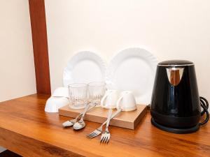 a coffee maker sitting on a wooden table with silverware at SS Luxury Comforts - Twin Sharing in Chikmagalūr