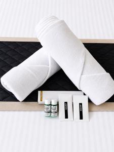 a pile of white towels on a shelf with four products at SS Luxury Comforts - Twin Sharing in Chikmagalūr +2 photos