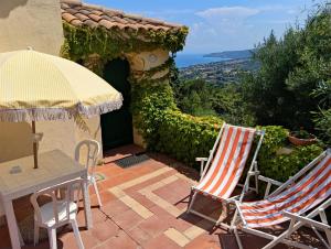 two chairs and a table and an umbrella on a patio at Appartamenti Salato in Tropea