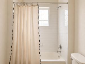 a bathroom with a shower curtain and a tub at Houston House Downtown Stays - Free Parking in Houston