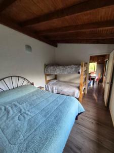 a bedroom with a bed and a wooden floor at cabaña los ulmos in Lago Ranco