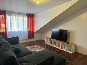 a living room with a couch and a flat screen tv at La Maison Blanche, 2 bedrooms in Macouria