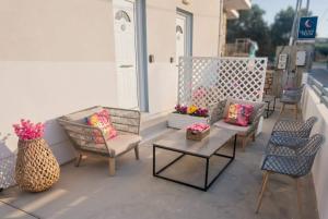 a patio with chairs and tables and flowers on a building at Divine Studios A1 in Elafonisos