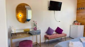 a living room with a mirror and a table and a couch at Divine Studios A1 in Elafonisos