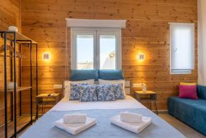 a bedroom with a bed and a blue couch at Divine Studios A1 in Elafonisos