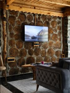 a living room with a stone wall with a tv on it at Altın Vadi Konaklama in Fındıklı